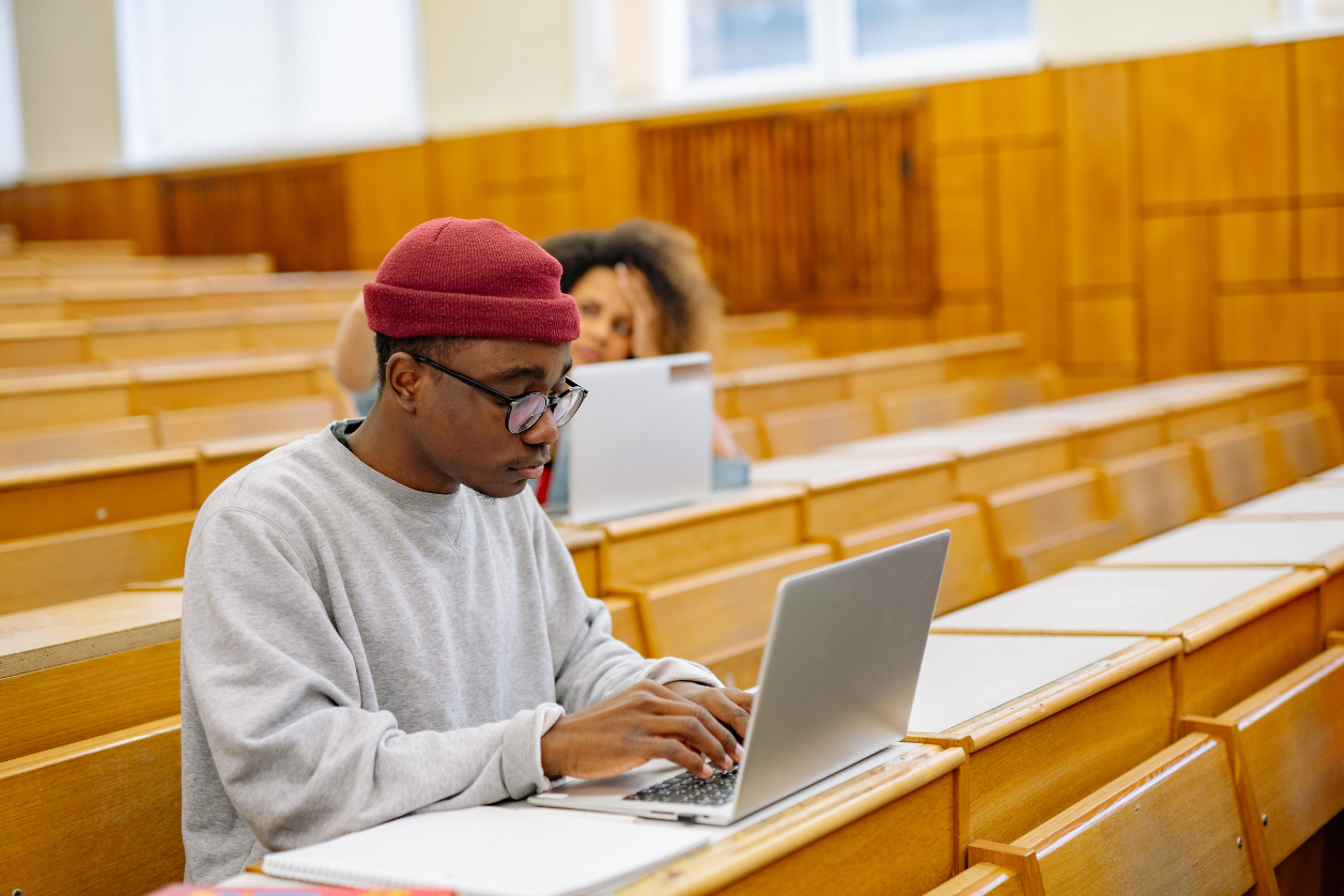 Étudiant préparant son dossier sur ordinateur